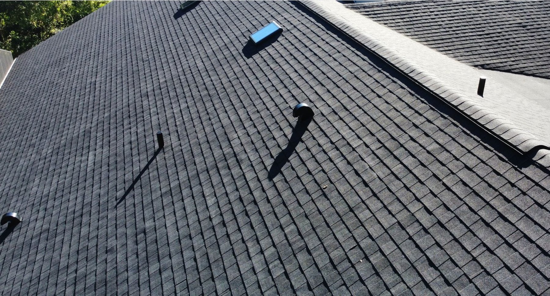 Dark architectural shingle roof in Brandon with turtle vents, a gooseneck, and pipe boots
